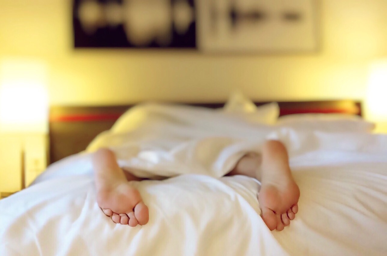ベッドで眠る女性の足