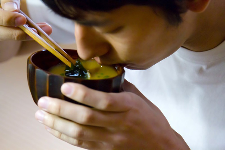 味噌汁を飲む男性